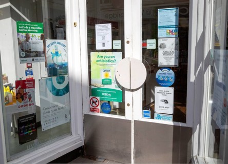 Advertisting information posters in pharmacy shop doorway
