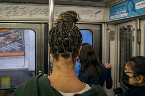 Woman with braided pigtails in the metro