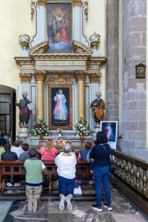 People praying at altar inside cathedral church