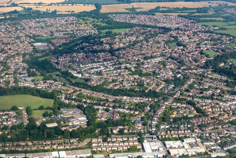 Oblique aerial view through plane window of housing estates in Bishop's Stortford town