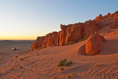 Landcruiser in the last evening light in front of the Flaming Cliffs