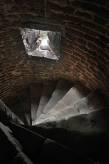 Narrow stone spiral staircase with loophole in the medieval Beersel Castle