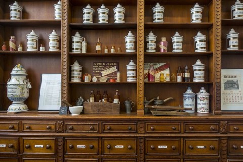 Antique pharmacy cabinet with vintage porcelain jars in the Hopital Notre-Dame a la Rose