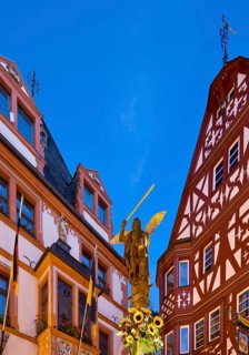 St. Michael's Fountain with town hall and gabled half-timbered house in the evening