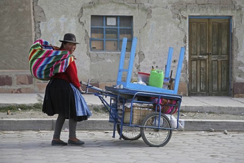 Traditional dressed Bolivian woman with pushcart going to market in Challapata
