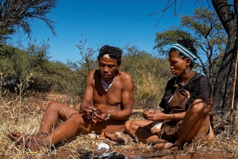 Bushman and San woman making fire in Kalahari