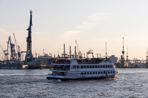 Party guests on the excursion ship MS Princess at dusk underway on the Elbe in Hamburg harbour