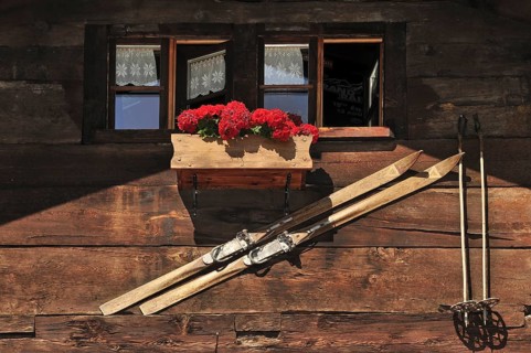 Housefront of traditional wooden house decorated with old skis in the Alpine village Grimentz