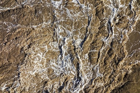 Turbulent muddy sea water caused by ship's screw causing turmoil in wake of boat