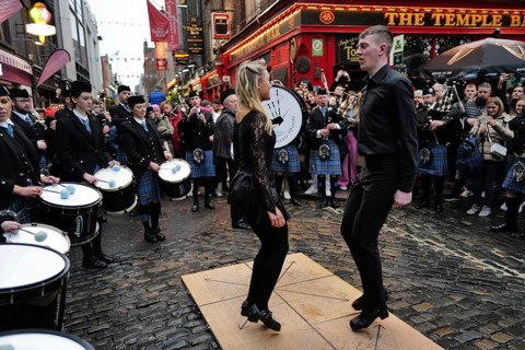Dancers performing to music being played by the Clew Bay Pipe band in Temple Bar during Trad Fest. Temple Bar
