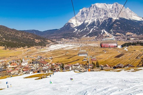 Plattensteig ski slope in the Grubigstein ski area with a view of the Zugspitze and the valley town of Lermoos