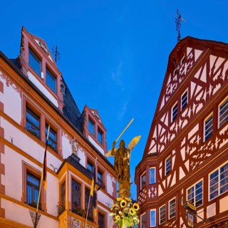 St. Michael's Fountain with town hall and gabled half-timbered house in the evening