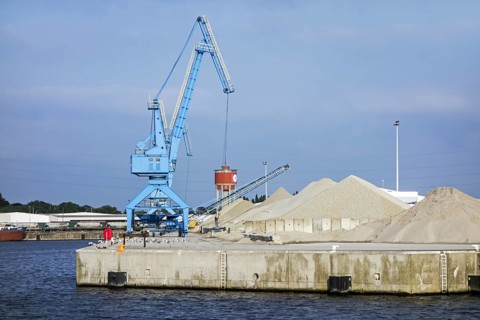 Dock crane and heaps of sand at the Ch. Kesteleyn gravel terminal in the port of Ghent