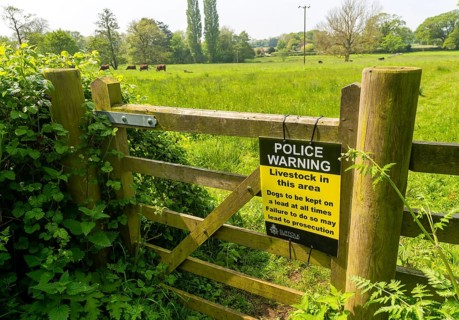 Police warning sign on gate about livestock in field