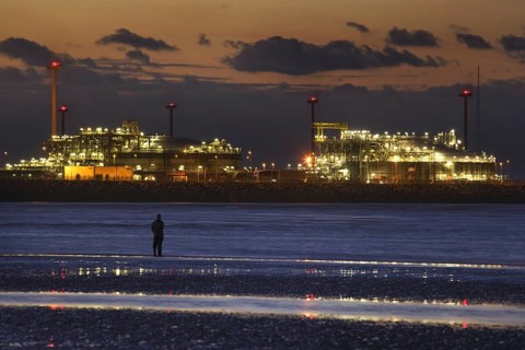 Man looking at the Zeebrugge North Sea port at sunset