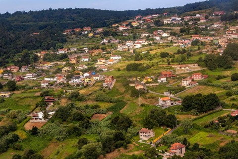 View through plane window of rural landscape and settlement of Negros approaching airport at Vigo