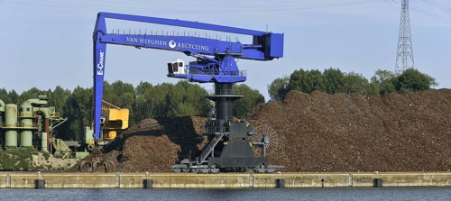 Dock crane and scrap heap along the Ghent-Terneuzen Canal at Ghent seaport