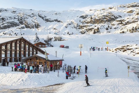 Skiers and snowboarders at apres-ski bar in Swiss ski resort in the Alps in winter