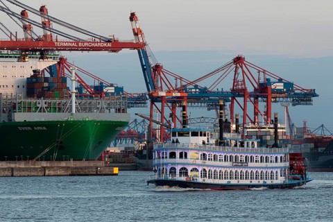 The MS Louisiana Star of the Elbreederei Abicht on a harbour cruise at dusk on the Elbe in front of container ships at the Burchardkai terminal in the Port of Hamburg