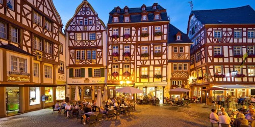 Gabled half-timbered houses on the busy medieval market square in the evening