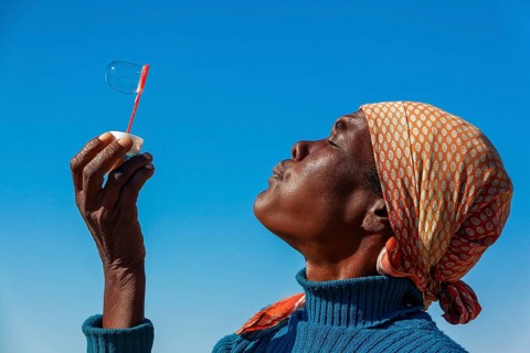 African woman making soap bubbles