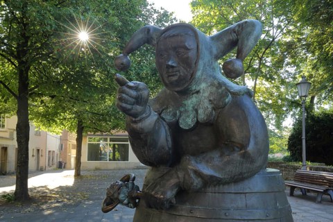 Sculpture Till Eulenspiegel with wine barrel in backlight