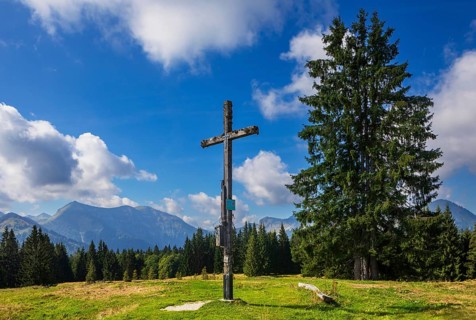 Summit cross on the Breitenberg with a view of the Osterhorn