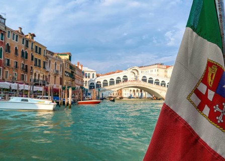 Beautiful view of Italian maritime flag and bridge of Rialto or ponte Rialto on Grand Canal on Venice
