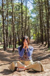 Kali mudra executed in lotus position by a woman in a forest