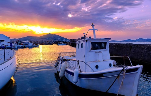 Colorful sunset over quiet Greek fishing village and its harbour