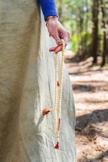 Close up of a japa mala holded by a woman hand