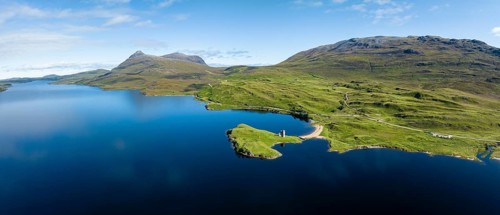 Aerial panorama of the freshwater loch Loch Assynt with the ruins of Ardvreck Castle on a peninsula