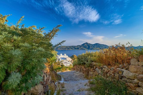Beautiful view of typical Greek village by seafront in evening. Whitewashed houses