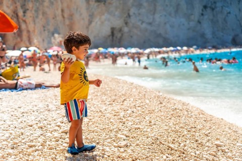 Boy having fun on Porto Katsiki beach in summer vacation Lefkada island