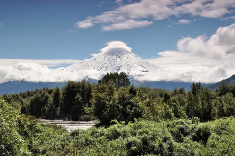 The snow-covered Osorno volcano with a storm cloud at the summit