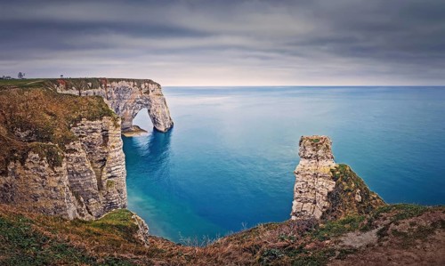 Beautiful view to the Porte d'Aval natural arch at Etretat famous cliffs in Normandy