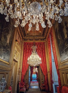 Beautiful decorated Napoleon apartments at Louvre palace. Royal family rooms with cardinal red curtains