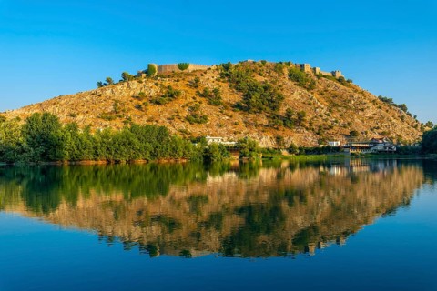 View of Rozafa Castle from a boat on a sightseeing excursion on Lake Shkoder in Shiroka. Albania