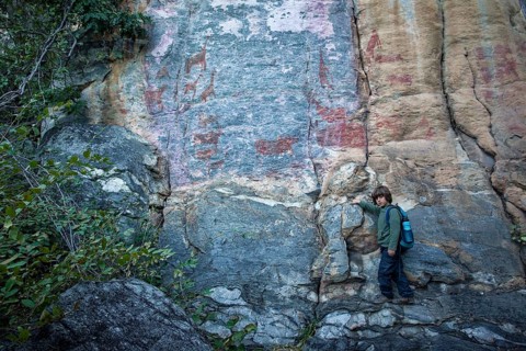 Boy in front of rock rock painting
