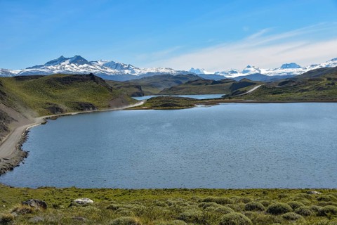 Gravel road in Torres del Paine National Park with snow-capped mountains