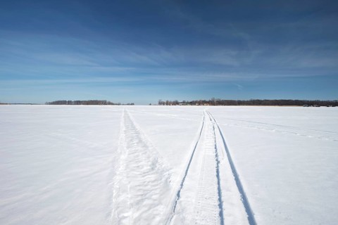 Vehicle tracks on snow covered frozen river