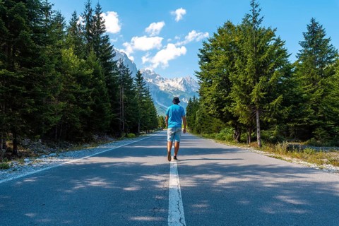 Young tourist walking on the road in Valbona valley