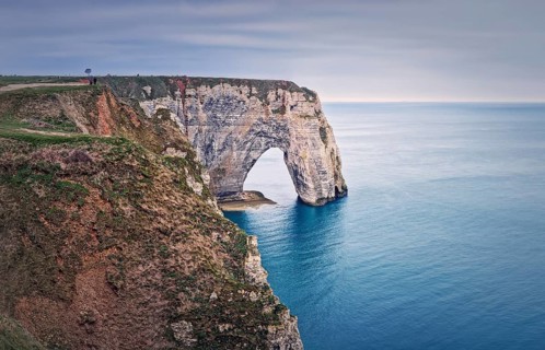 Sightseeing view to the Porte d'Aval natural arch cliff washed by Atlantic ocean waters at Etretat