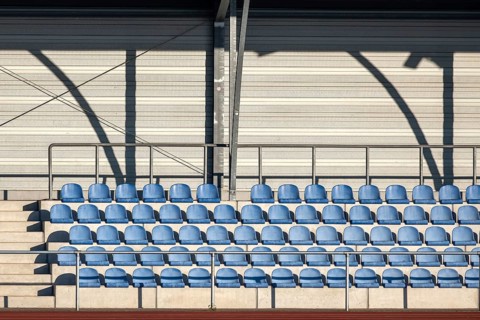 Grandstand with blue seating shells in a sports stadium