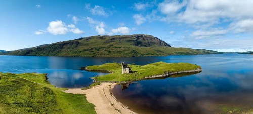 Aerial panorama of the freshwater loch Loch Assynt with the ruins of Ardvreck Castle on a peninsula