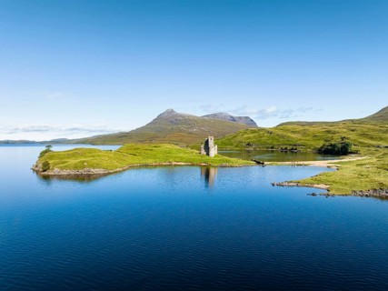 Aerial view of the freshwater loch Loch Assynt with the ruins of Ardvreck Castle on a peninsula