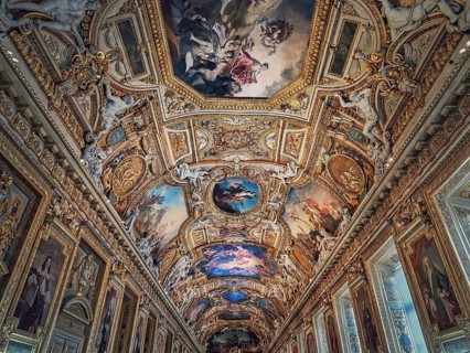 The Galerie d'Apollon a large and iconic room of the Louvre museum. Apollon gallery is a gold decorated hall with zodiac signs ornaments and murals on the walls and ceiling. Architectural masterpiece