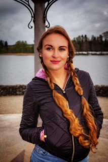 Portrait of a young woman with long braids dressed in an anorak in rainy weather
