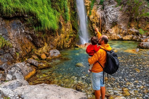 Man with his son at Grunas waterfall in Theth national park