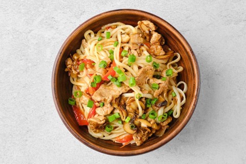 Top view of udon noodle with pork and mushrooms in sweet chilli sauce